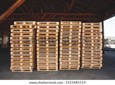 The wooden pallets stacked on top of each other in several rows in a warehouse