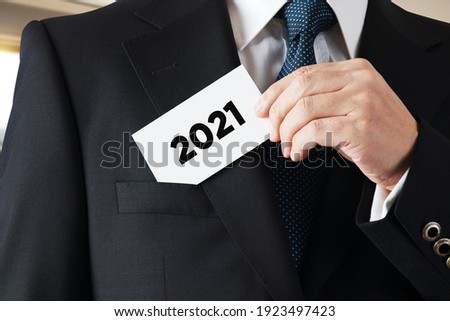 Businessman takes out a business card with the year 2021 written on it. Year 2021 business plans or aspirations.

