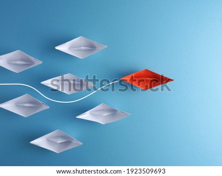 New ideas, creativity and various innovative solutions or leadership concept paper boats on a blue background