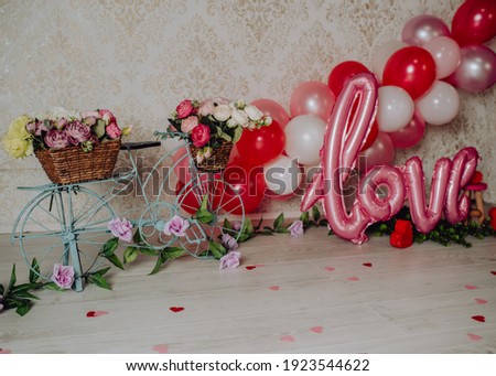 San Valentin mini photoshoot for babies and toddlers in a photo studio with a bicycle full of flowers and balloons