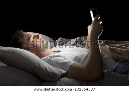 male in bed browsing the internet late at night with a tablet Royalty-Free Stock Photo #192354587