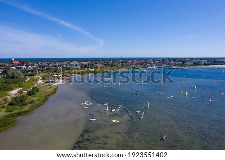 People windsurfing in the sea. Summer sport learning how to windsurf. Windsurf board  on Puck bay in Jastarnia, Poland, Europe aerial drone photo view