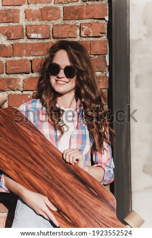 Fashion lifestyle, beautiful young woman with skateboard in city street