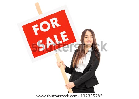 Female real estate agent holding a for sale sign isolated against white background