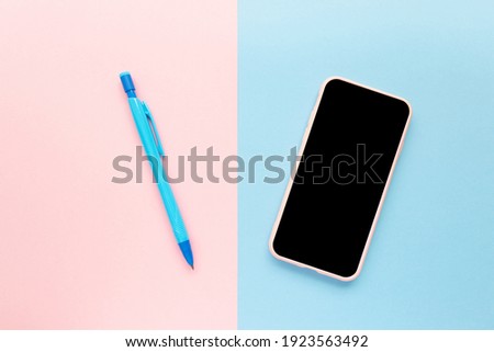 Workspace with pen and cellular phone with black screen