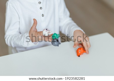 A boy plays with finger dolls. Close up.