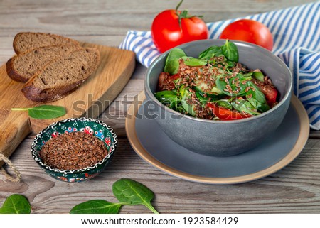 Salad with tomatoes, cucumber, avocado, spinach, flaxseed and flaxseed oil. Healthy food rich in vitamins, antioxidants, fiber. Royalty-Free Stock Photo #1923584429