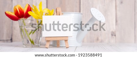 Tulip flower in glass vase over wooden table background wall for Mother's Day design concept.