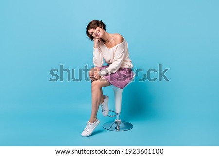 Photo portrait full body view of adorable girl resting head on hand sitting on bar stool isolated on pastel blue colored background