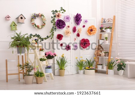 Easter photo zone with plants and paper flowers indoors