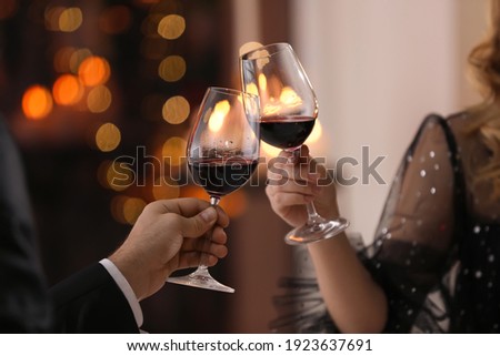 Couple clinking glasses at Valentine's day dinner in restaurant, closeup Royalty-Free Stock Photo #1923637691