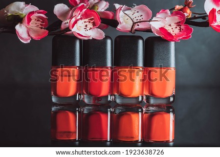Red nail varnish or polish isolated on black mirror surface background with reflection.