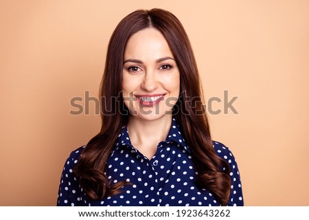 Photo of nice happy mature woman wear blue dotted shirt smile good mood isolated on pastel beige color background