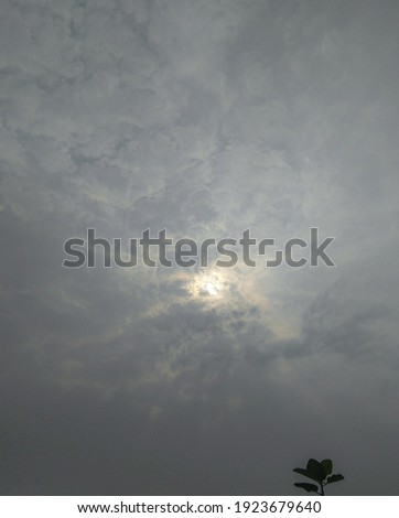 Sunset scenery view of sun hiding behind black clouds in sky background, nature photography, weather conditions