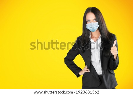 Concept of coronavirus. Portrait of smiling woman in face mask, showing okay sign
