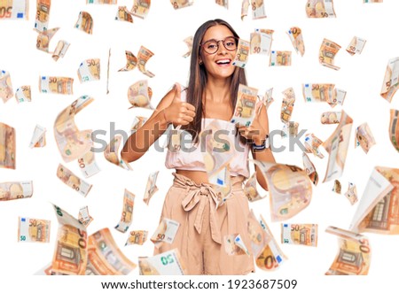 Young hispanic woman wearing casual clothes and glasses success sign doing positive gesture with hand, thumbs up smiling and happy. cheerful expression and winner gesture.