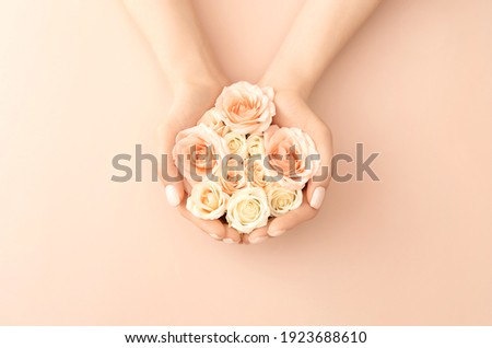 Female hands holding tea roses on pastel background for decoration design. Vintage pink gift card. Love and romance concept. Beauty concept. Flat lay style. Copy space.