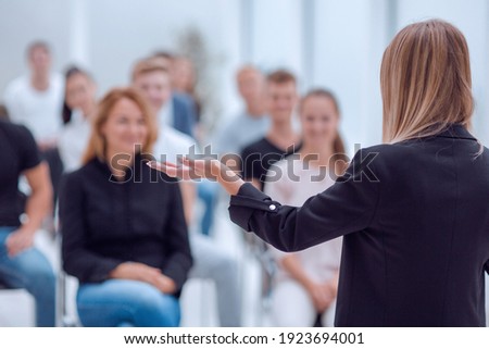 rear view. young woman doing a report for a group of young people Royalty-Free Stock Photo #1923694001