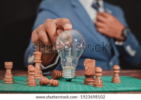 The business man wears a modern suit on the hand of a businessman showing a light bulb as the cog of working as a management system. The concept of working as a system Driving business