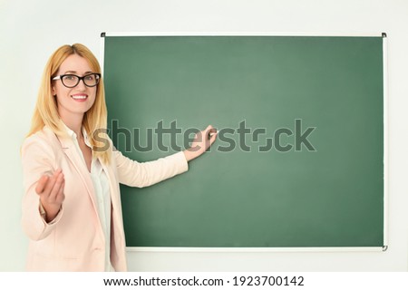 English teacher near green chalkboard at lesson