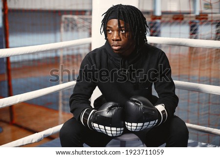 Sporty man boxing. Photo of boxer on a ring. African american man training.