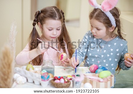 Bokeh shapes, selective focus, special blur, two girls with bunny ears are painting Easter eggs, children are preparing for the spring holiday, Easter mood.
