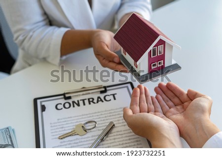 Real estate brokerage agent Deliver a sample of a model house to the customer. And contract home insurance concept agreement Making lease and buying a house