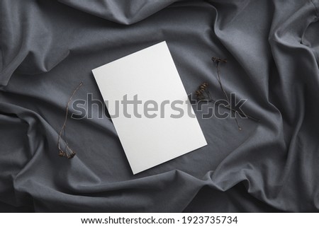 Clean greeting card, invitation or postcard mock up on black wavy cloth.