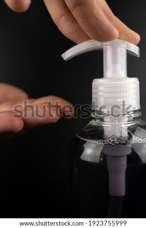 Hand cleaning gel. Pouring sanitising hand gel onto the fingers of a hand.