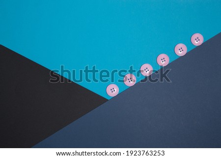 Geometric composition with pink buttons. Black, blue, blue paper. Crossing flowers. Classic colors. Business style.