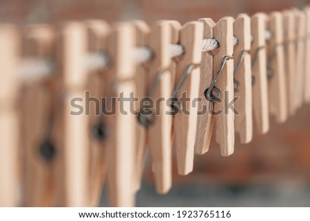 Wooden clothespins on a rope. Selective focus on one clothespin. Copy, empty space for text. Royalty-Free Stock Photo #1923765116
