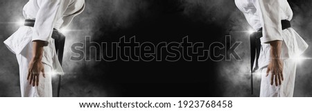 Martial arts masters on dark smoke background. Sports banner Royalty-Free Stock Photo #1923768458
