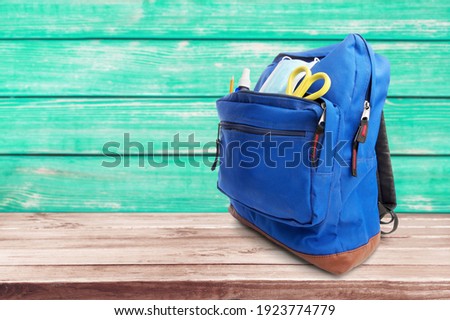 Classic school backpack with colorful school supplies and books Royalty-Free Stock Photo #1923774779