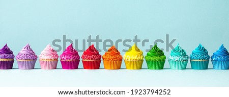 Row of colorful cupcakes in rainbow colors Royalty-Free Stock Photo #1923794252