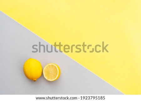 abstract modern handmade paper background with lemon half in ultimate gray and illuminating yellow colors
