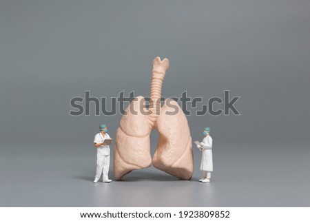 Miniature people doctor and nurse observing and discussing about human lungs , Virus and bacteria infected Concept