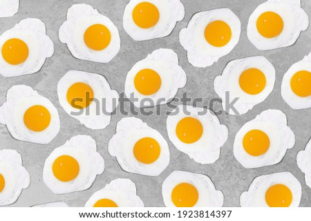 Fried eggs on a grey background pattern. Colors of the year 2021, Illuminating and Ultimate Grey.