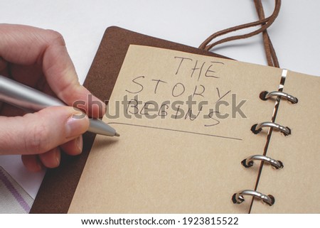 Diary with handwritten text The story begins. Concept of the beginning of a new story. Royalty-Free Stock Photo #1923815522