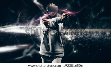 Image of a beautiful stylish woman wearing VR glasses and holding joysticks. Virtual reality concept. Mixed media