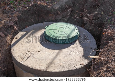 Septic tank made of concrete rings with a hatch for a private country house. Wastewater and sewerage drainage. Royalty-Free Stock Photo #1923833795