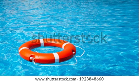 lifebuoy on the blue water with the glare of the sun Royalty-Free Stock Photo #1923848660