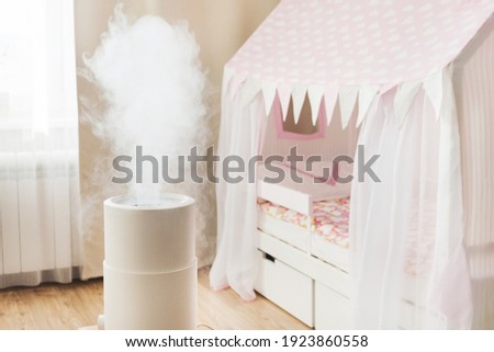 Modern air humidifier in children's room, aroma oil diffuser at home. Improving the comfort of living in a house, Improving the well-being. Baby care Royalty-Free Stock Photo #1923860558