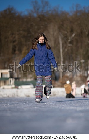 pretty cheerful girl skating outdoors on lake