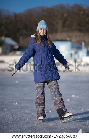 pretty cheerful girl skating outdoors on lake