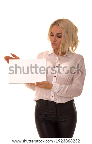 Young girl holding blank page for advertising. Beautiful girl in a white shirt holds a sign in her hands.