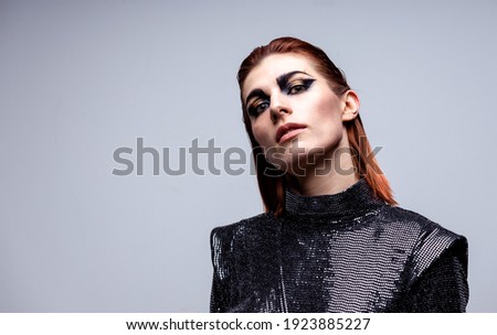 portrait of a beautiful red-haired girl in a shiny dress