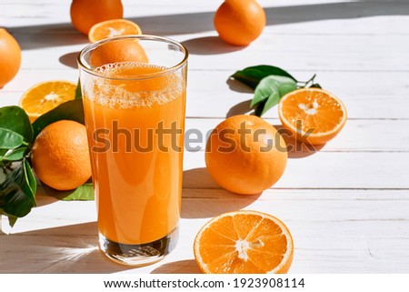 Ripe bio oranges and a glass of fresh squeezed orange juice on white wooden background. Organic Sicilian oranges Royalty-Free Stock Photo #1923908114