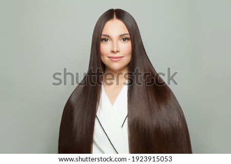 Cute young woman with long healthy straight hair on white background. Haircare concept