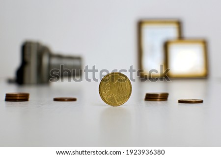 10 cents coin close up on blurred background with camera and photo frames