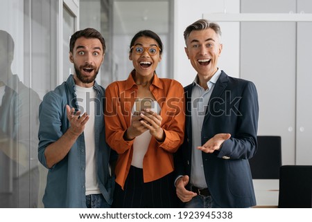 Portrait of multiracial emotional business people working in modern office. Group of overjoyed creative colleagues looking at camera. Join out team concept  Royalty-Free Stock Photo #1923945338